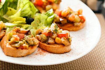 bruschetta with vegetables on white plate
