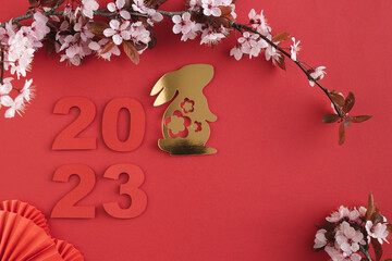 Chinese New Year, year of the rabbit. Year 2023 with golden rabbit and plum blossom fans. Copy...