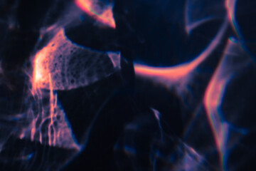 Fototapeta premium Blur colorful warm pink rainbow light leaks on black background. Defocused abstract analog retro film lens flare bokeh overlay or screen filter effect. Glow Vintage prism, water caustic, surreal light