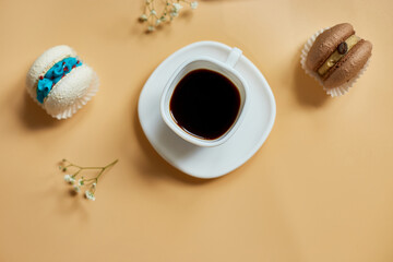 Top view, flat lay cake macaron, french cookies macaroons and cup of coffee on orange background,...