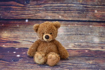teddy bear soft toy on brown wooden background