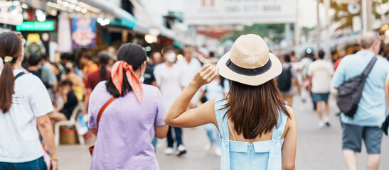woman traveling with hat, Asian traveler standing at Chatuchak Weekend Market, landmark and popular...