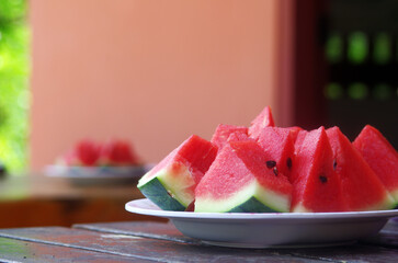 Slice fresh watermelon on a plate and serve with food.