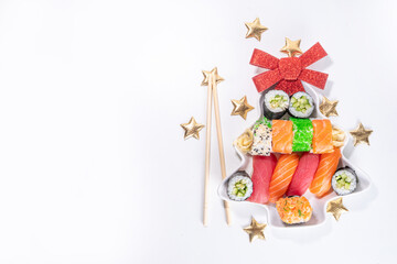 Sushi for Christmas New Year party, winter holiday food delivery menu mockup.  Sushi set on Christmas tree form plate and slate board, with Xmas decoration copy space