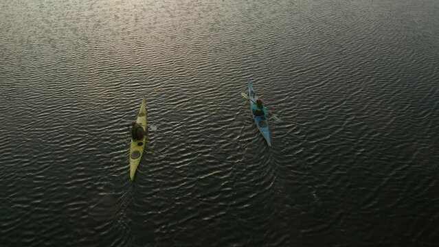 Couple padeling kayac in the sunset