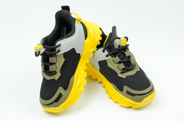 Children's sports sneakers with a yellow sole on a white background. Khaki sneakers. Sports boots.