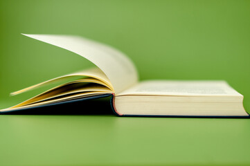 open book on green background reading concept