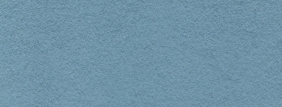 Texture of old light blue color paper background, macro. Structure of a vintage craft denim cardboard.