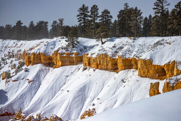 winter landscape of bryce canyon national park; freezing cold red rocks covered with snow, winter...