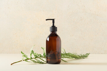 Pump amber glass bottle on beige background. Soap liquid, shampoo or shower gel packaging design