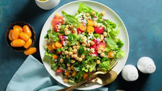 Tabbouleh salad. Tabouli salad with fresh parsley, onions, tomatoes, bulgur and chickpea. Healthy vegetarian food, diet. Video 4k.
