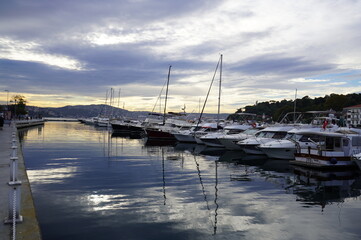 Sailboats at Tarabya yacht marina in Istanbul. Reflection of yachts and hotel. Blue sky and natural white clouds.