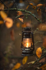 Fototapeta na wymiar Photo of a kerosene black lantern in an autumn forest.