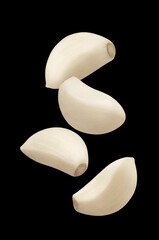 Flying garlic cloves, isolated on black background