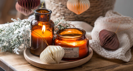The concept of New Year and Christmas. Home warmth in cold weather. Still-life. Scandinavian-style paper Christmas tree toys on fir branches and candles on a coffee table in the living room interior.