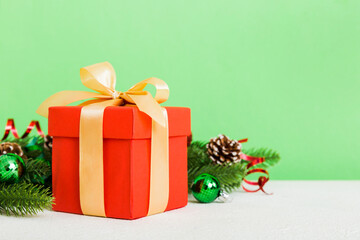 New Year Christmas mood, gift box, branches of a christmas tree, New Year decorations on a colored background