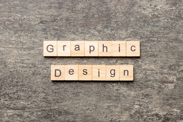 Fototapeta premium graphic design word written on wood block. graphic design text on cement table for your desing, concept