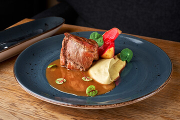 Restaurant Food - Filet mignon with celery cream puree and jubard sauce on a white plate.