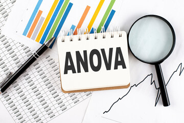 ANOVA text on notebook on the graph background with pen and magnifier - obrazy, fototapety, plakaty