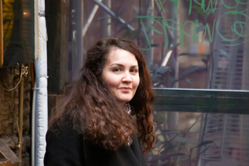 Fototapeta na wymiar Beautiful curly haire brunette girl on street urban background in springtime Budapest