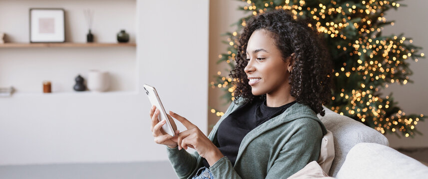 Young woman using smartphone at home during Christmas holiday, Student girl texting on mobile phone banner, Connection, online shopping, winter lifestyle concept