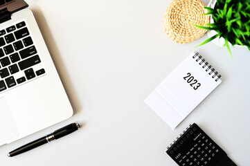 Working with Laptop computer,Smartphone calendar 2023 and cactus copy space on modern table background.Top view,Flat lay,style Minmal workspace,business Concept