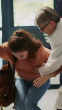 Vertical video: Female client fanting in pharmacy and feeling off, almost falling down and having vertigo sensation. Woman losing consciousness and balance near shelves, asking for assistance. Dutch
