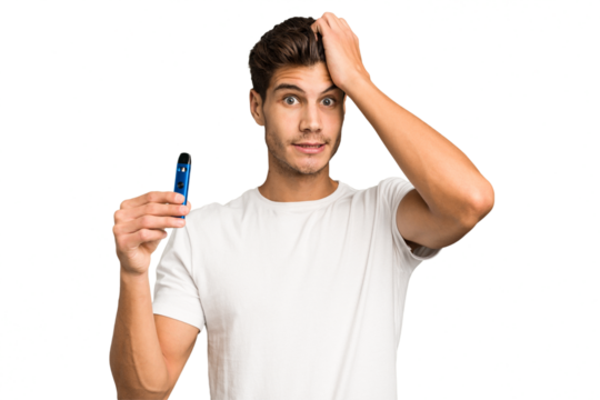Young caucasian man holding an electronic cigarette isolated being shocked, she has remembered important meeting.