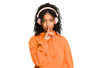 Young Brazilian woman listening to music with headphones isolated keeping a secret or asking for silence.