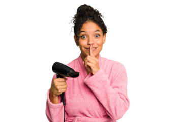 Young brazilian woman wearing a pink bathrobe holding an hairdryer isolated keeping a secret or asking for silence.