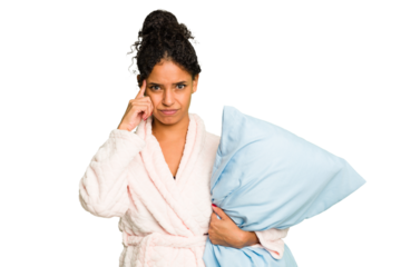 Young brazilian woman wearing a pajama holding a pillow isolated pointing temple with finger, thinking, focused on a task.