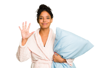 Young brazilian woman wearing a pajama holding a pillow isolated smiling cheerful showing number five with fingers.