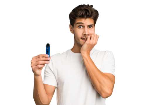 Young caucasian man holding an electronic cigarette isolated biting fingernails, nervous and very anxious.