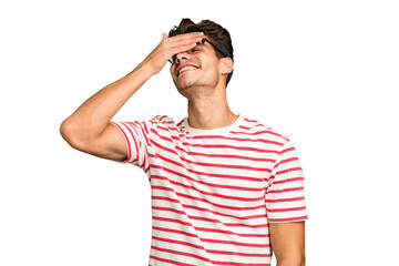 Naklejka premium Young caucasian handsome man isolated laughs joyfully keeping hands on head. Happiness concept.