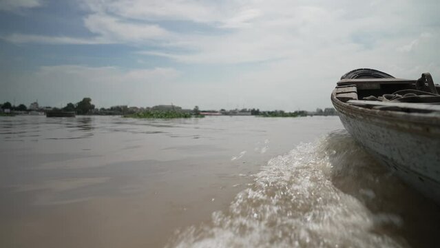 Wooden Boat crossing a River, Economic Challenges and Climate Change in Asia Mekong Delta River Ecology