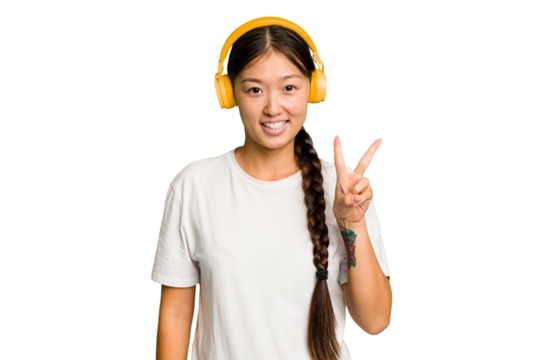 Young asian woman listening to music with headphones isolated showing number two with fingers.