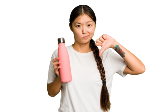 Young asian woman holding a pink thermo isolated showing a dislike gesture, thumbs down. Disagreement concept.