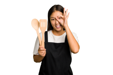 Young asian cook woman isolated excited keeping ok gesture on eye.
