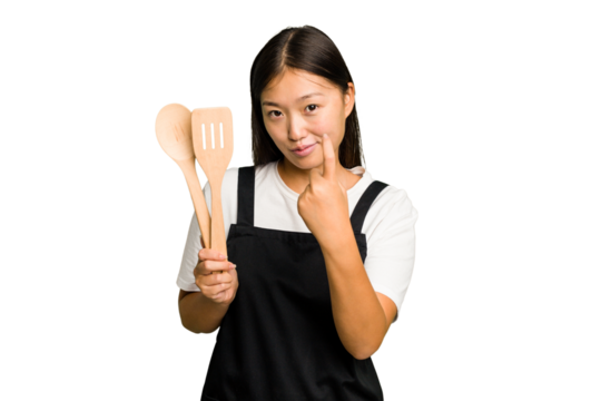 Young asian cook woman isolated pointing with finger at you as if inviting come closer.