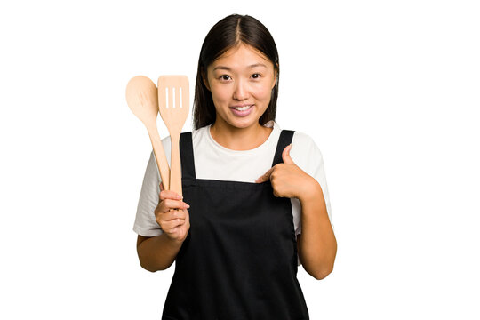 Young asian cook woman isolated person pointing by hand to a shirt copy space, proud and confident