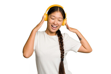 Young asian woman listening to music with headphones isolated