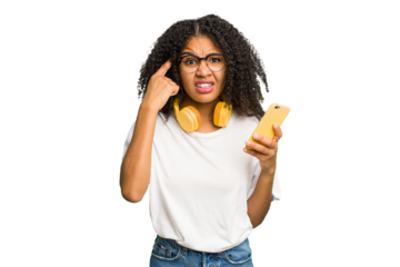 Young african american woman listening to music with yellow headphones isolated showing a disappointment gesture with forefinger.