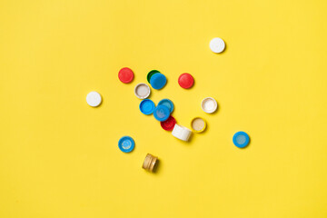 pile of colorful plastic caps for bottles on color table
