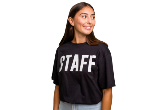 Young caucasian staff woman isolated looks aside smiling, cheerful and pleasant.