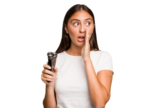 Young caucasian woman holding a razor isolated is saying a secret hot braking news and looking aside - Powered by Adobe