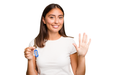 Young caucasian woman holding a home keys isolated smiling cheerful showing number five with fingers.