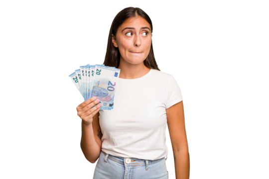 Young caucasian woman holding a banknotes isolated confused, feels doubtful and unsure.