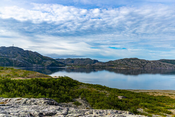 Fototapeta premium a calm sheet of water in a norwegian bay at sunrise; a morning in an arctic fjord; a vacation in the far north, a panorama of arctic norway