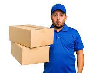 Delivery caucasian man isolated shrugs shoulders and open eyes confused.