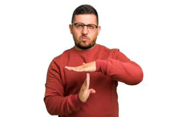 Young caucasian man isolated showing a timeout gesture.